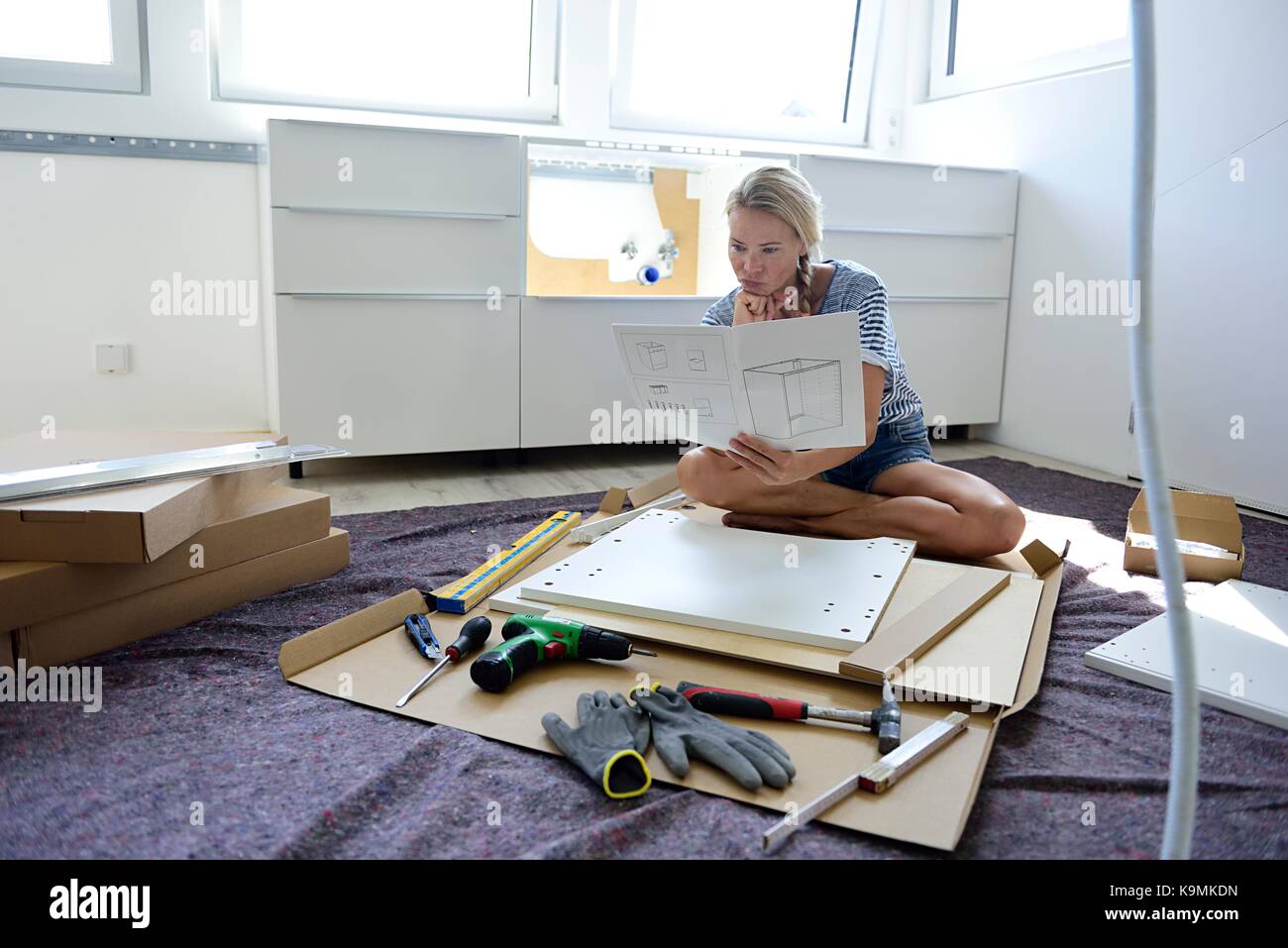 Woman reading assembly instructions at home Stock Photo Alamy