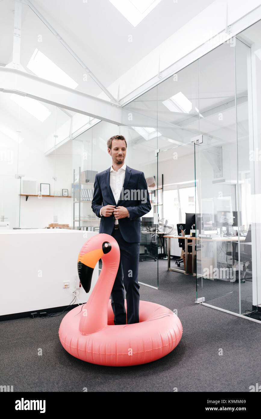 Businessman in office with inflatable flamingo Stock Photo - Alamy