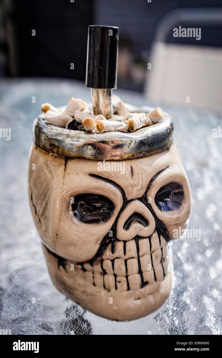 Skull Shaped Ashtray full of Cigarettes Ends Stock Photo