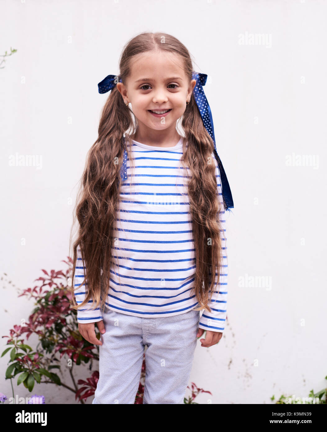 Portrait of smiling little girl with long braids Stock Photo - Alamy