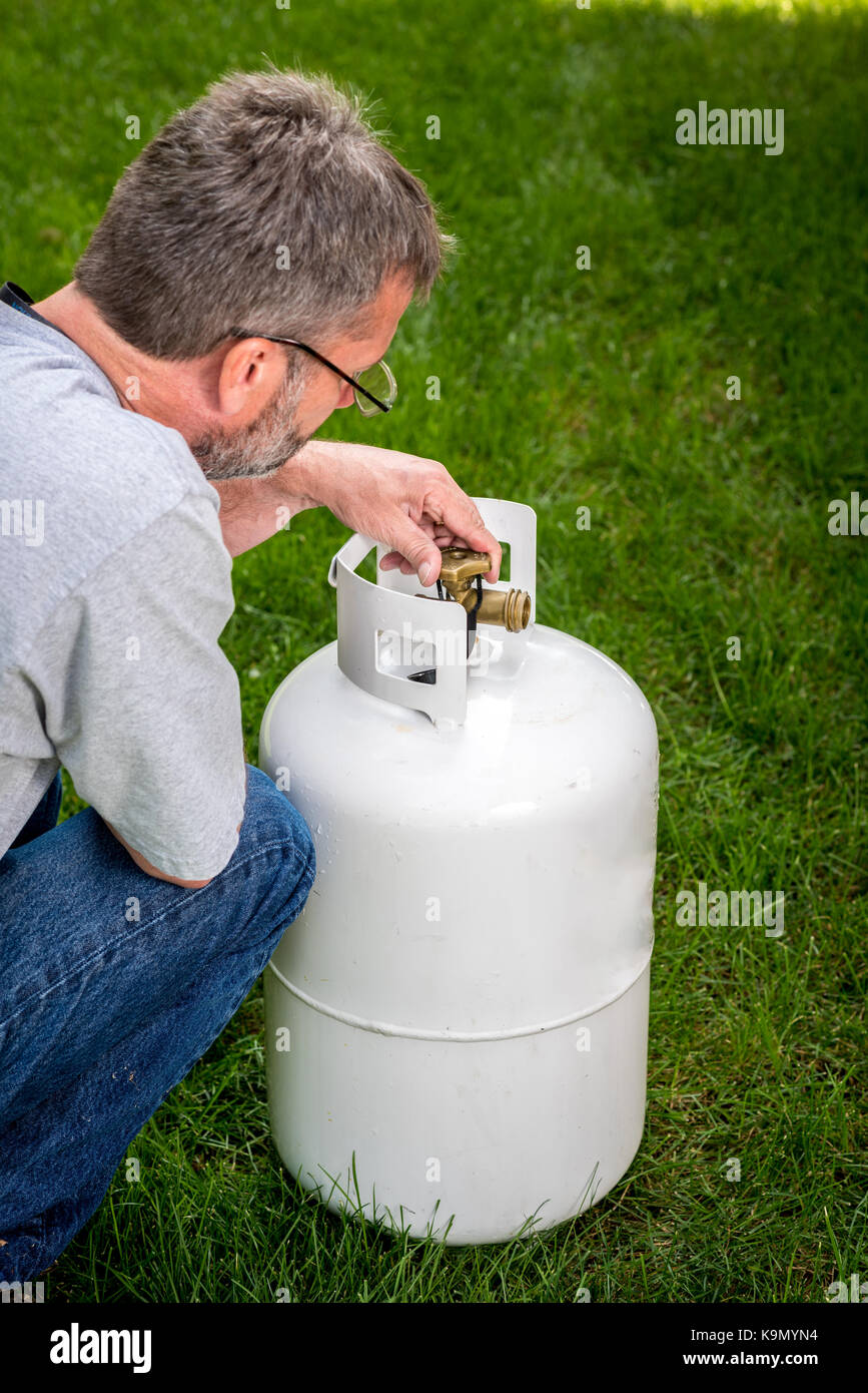 White propane tank and bras knob looked at by a man Stock Photo Alamy