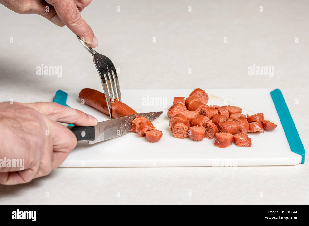 Demonstration of the proper way to cut hotdogs with a knife and fork