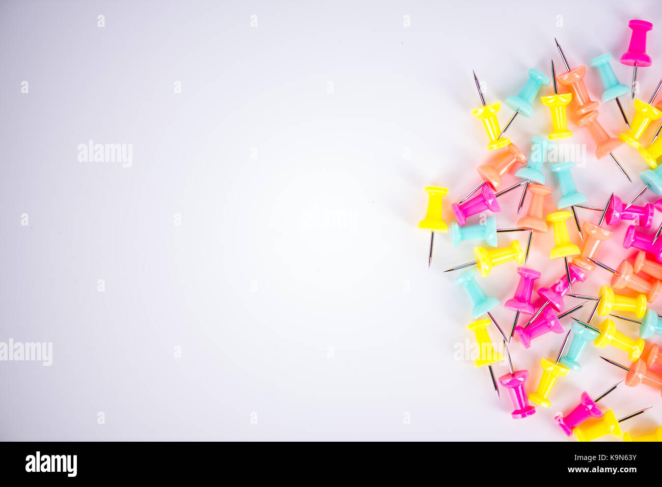 Colorful push pins on white background Stock Photo - Alamy