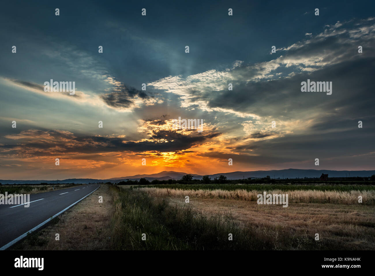 Highway Road at sunset with fields and dramatic cloudscape Stock Photo ...