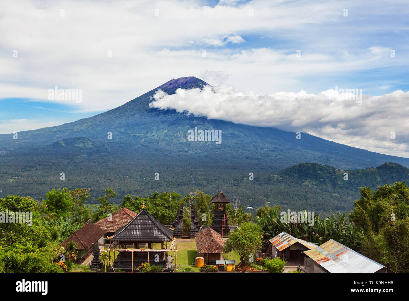 View from Lempuyang mountain to traditional Balinese temple on Mount Agung slopes background. Mount Agung is highest active volcano on Bali island Stock Photo