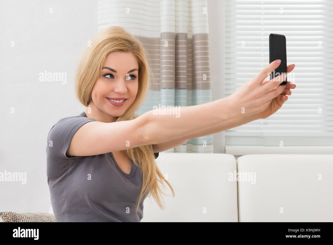 Young Happy Beautiful Woman Taking Selfie With Mobile Phone At Home ...