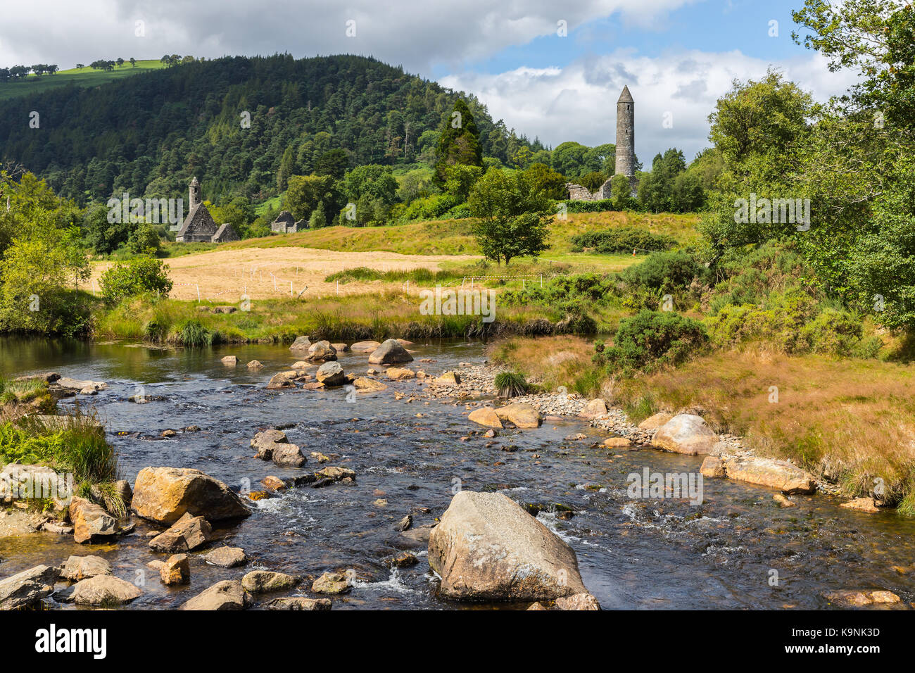 The round tower at Glendalough in County Wicklow, Ireland, renowned for an Early Medieval monastic settlement founded in the 6th century by St Kevin. Stock Photo