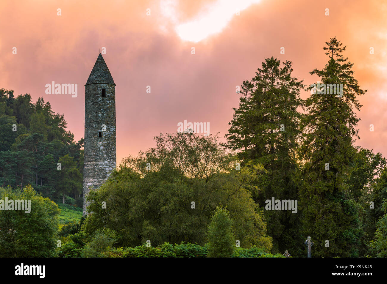 The round tower at Glendalough in County Wicklow, Ireland, renowned for an Early Medieval monastic settlement founded in the 6th century by St Kevin. Stock Photo