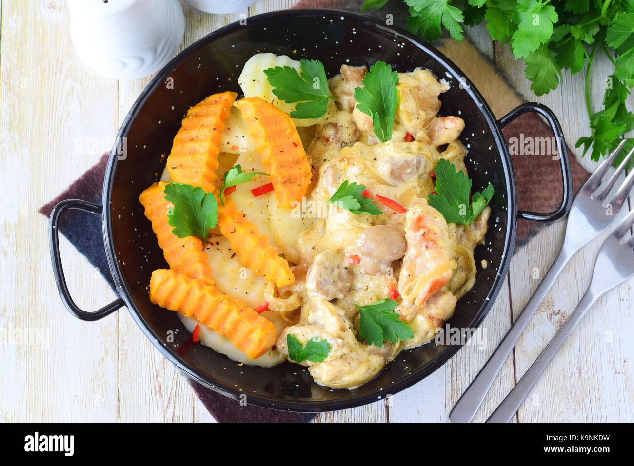 Chicken with mushrooms in a creamy sauce with fried sweet potato in a