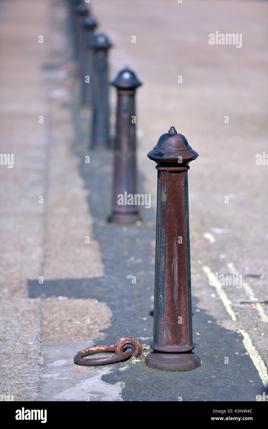 A row of cast iron bollards or stanchions set into the road to prevent traffic incursion and to controll parking in pedestrian only areas. Victorian. Stock Photo