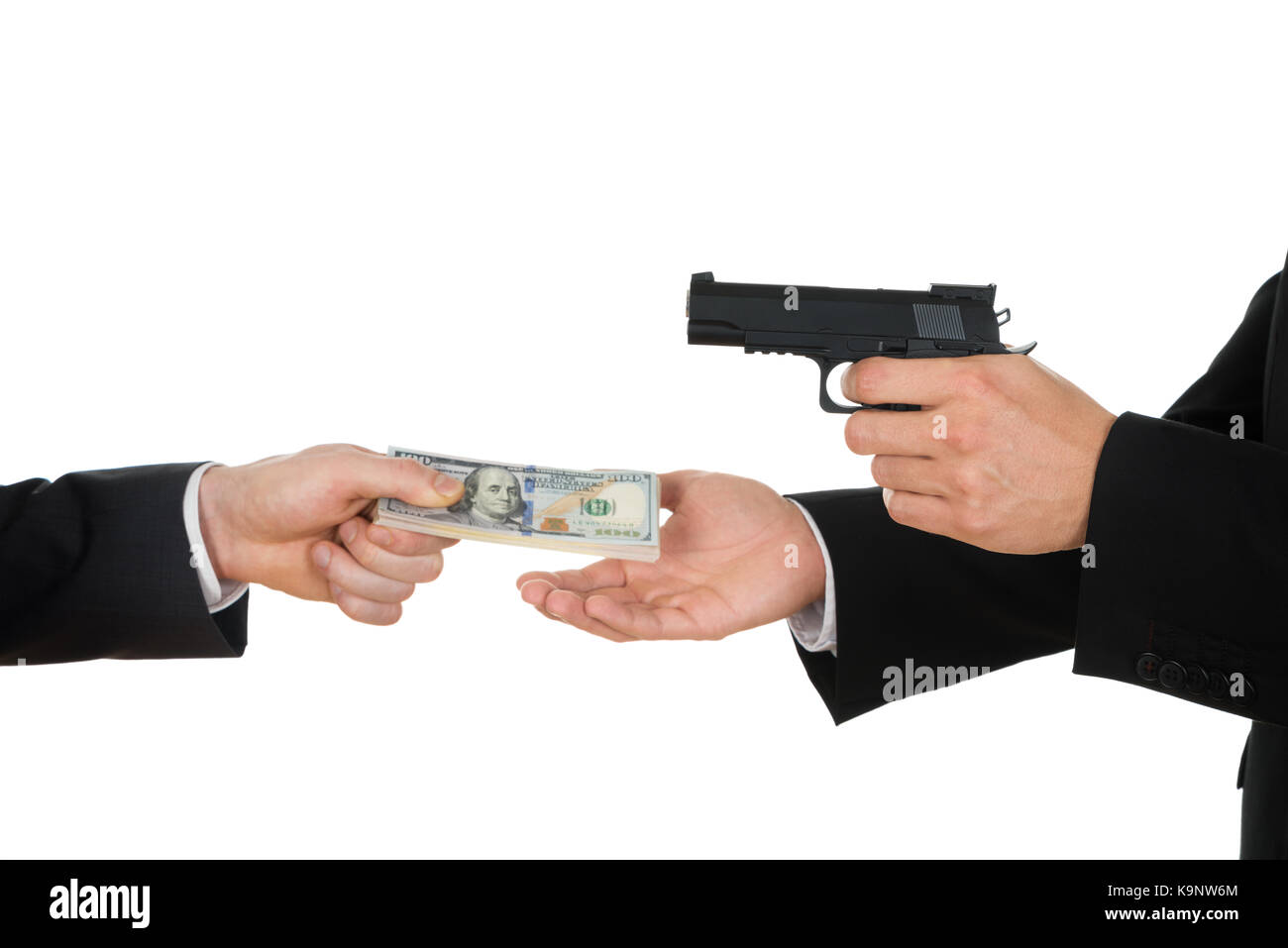 Businessman Hand Giving Money To A Person Aiming With Gun Over White Background Stock Photo