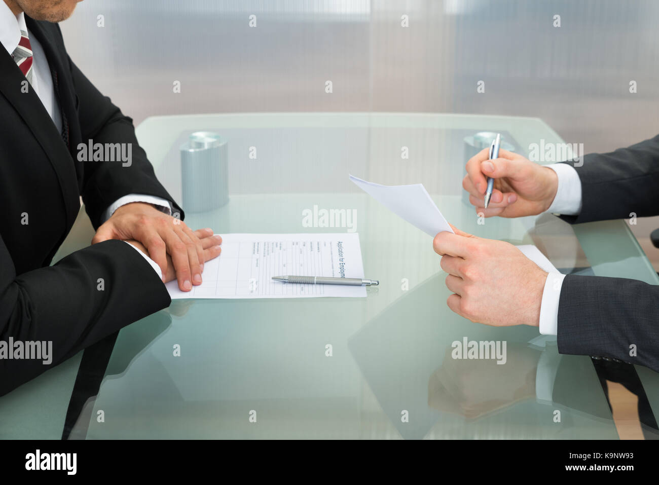 Businessman Conducting An Employment Interview With Application Form On Office Desk Stock Photo