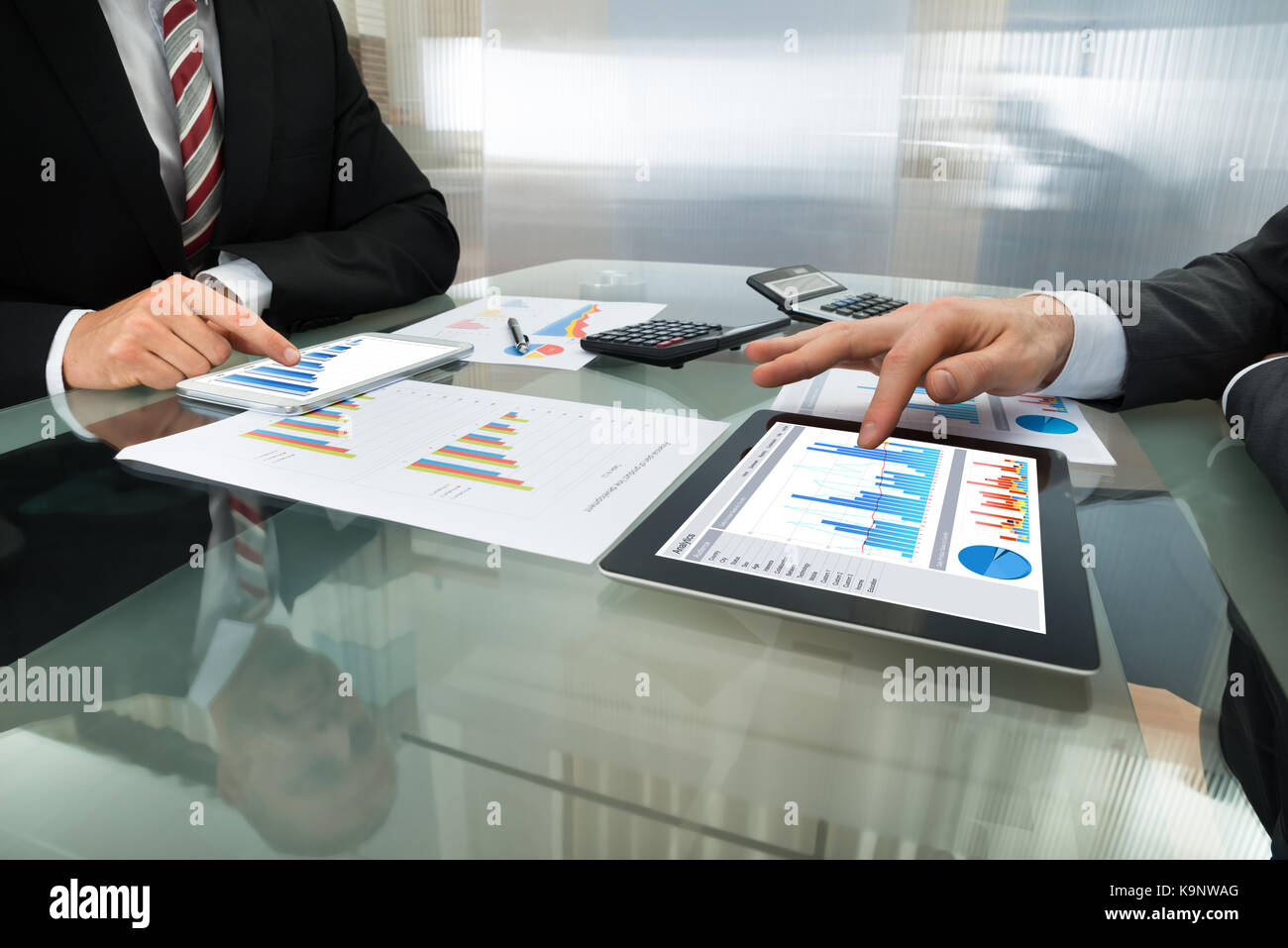 Close-up Of Two Businessman Analyzing Graph On Digital Tablet Stock Photo