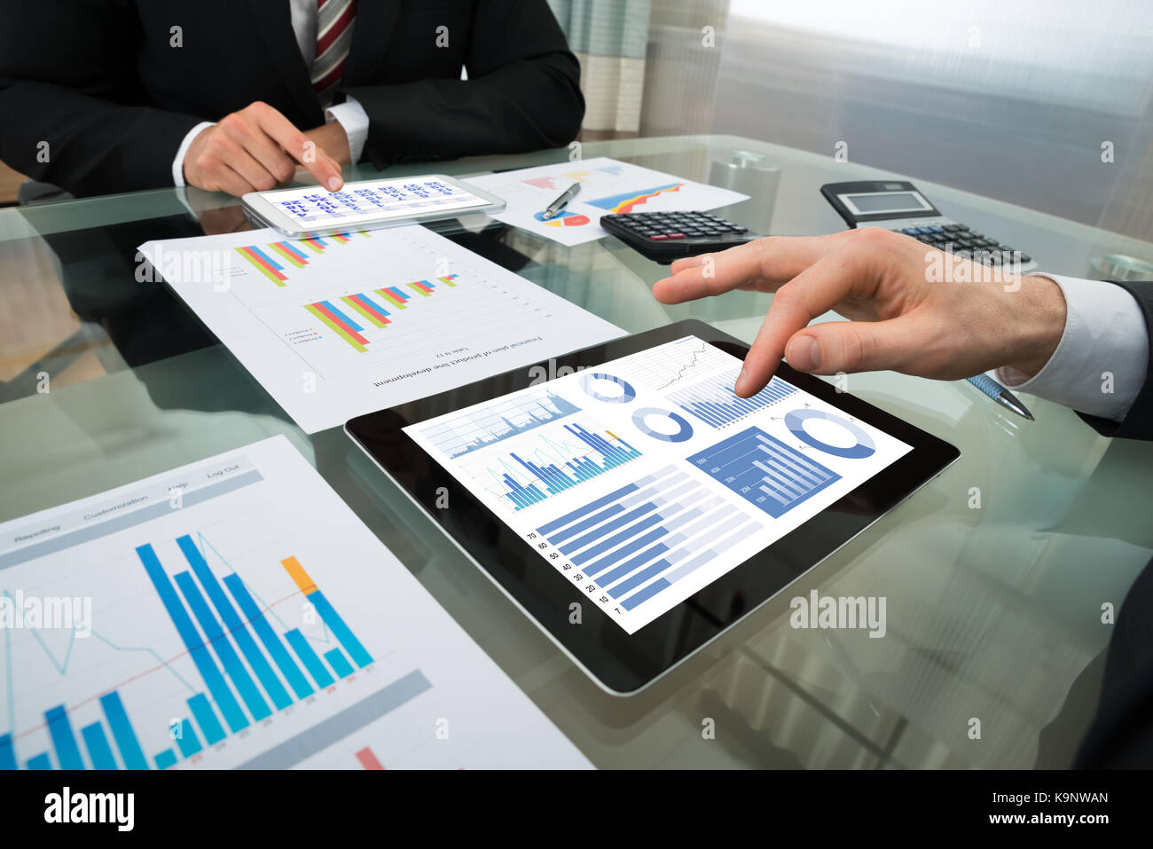 Close-up Of Two Businessman Analyzing Graph On Digital Tablet Stock Photo