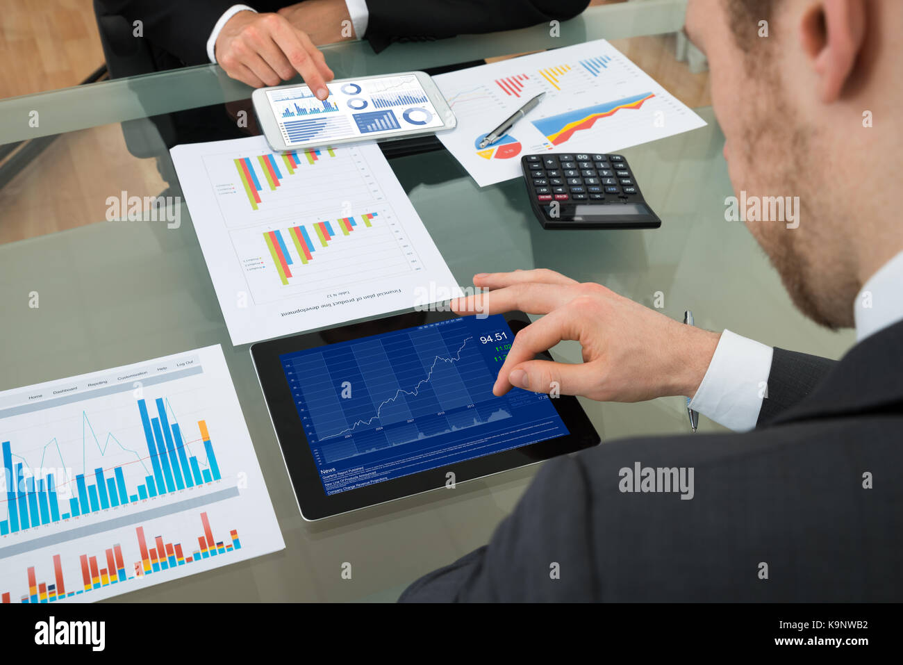 Close-up Of Two Businessman Analyzing Graph On Digital Tablet Stock Photo