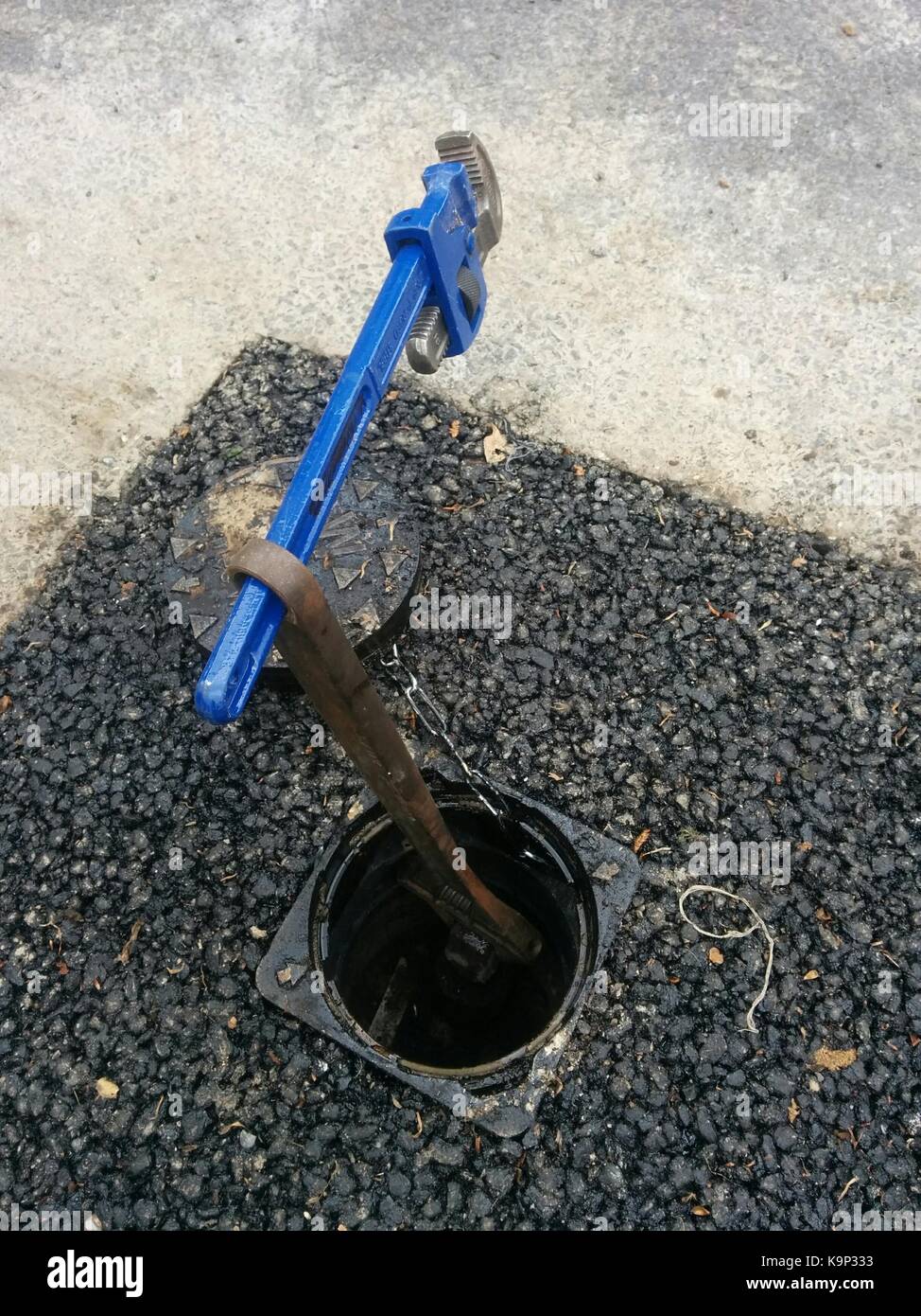 Improvising With Two Tools To Turn Off Water Main Stock Photo