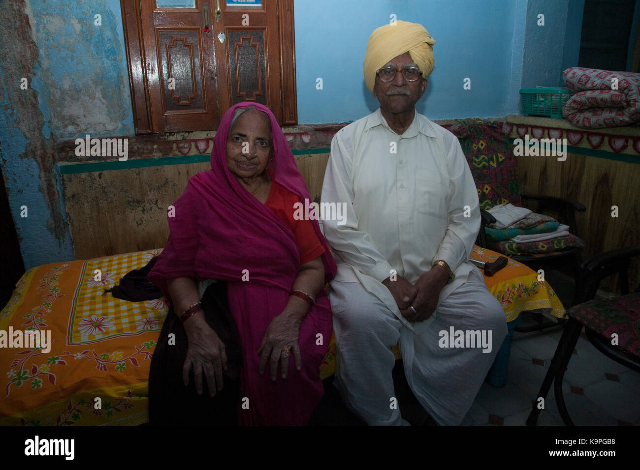 INDIAN ELDERLY COUPLE SITTING ON BED Stock Photo