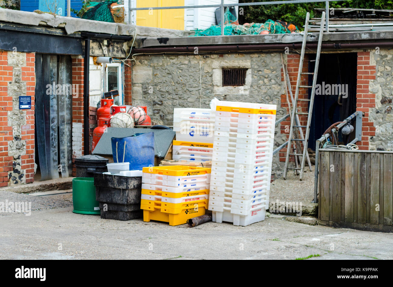 Boxes for fish and fishing equipment near the beach in Beer, Devon, UK Stock Photo