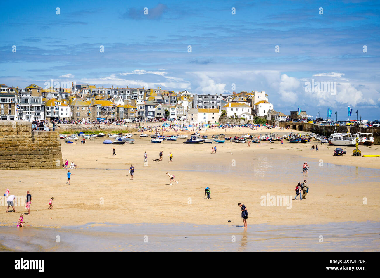 People on sandy beach in St Ives harbour at low tide. English coastal seaside town St Ives, Cornwall, England UK Stock Photo