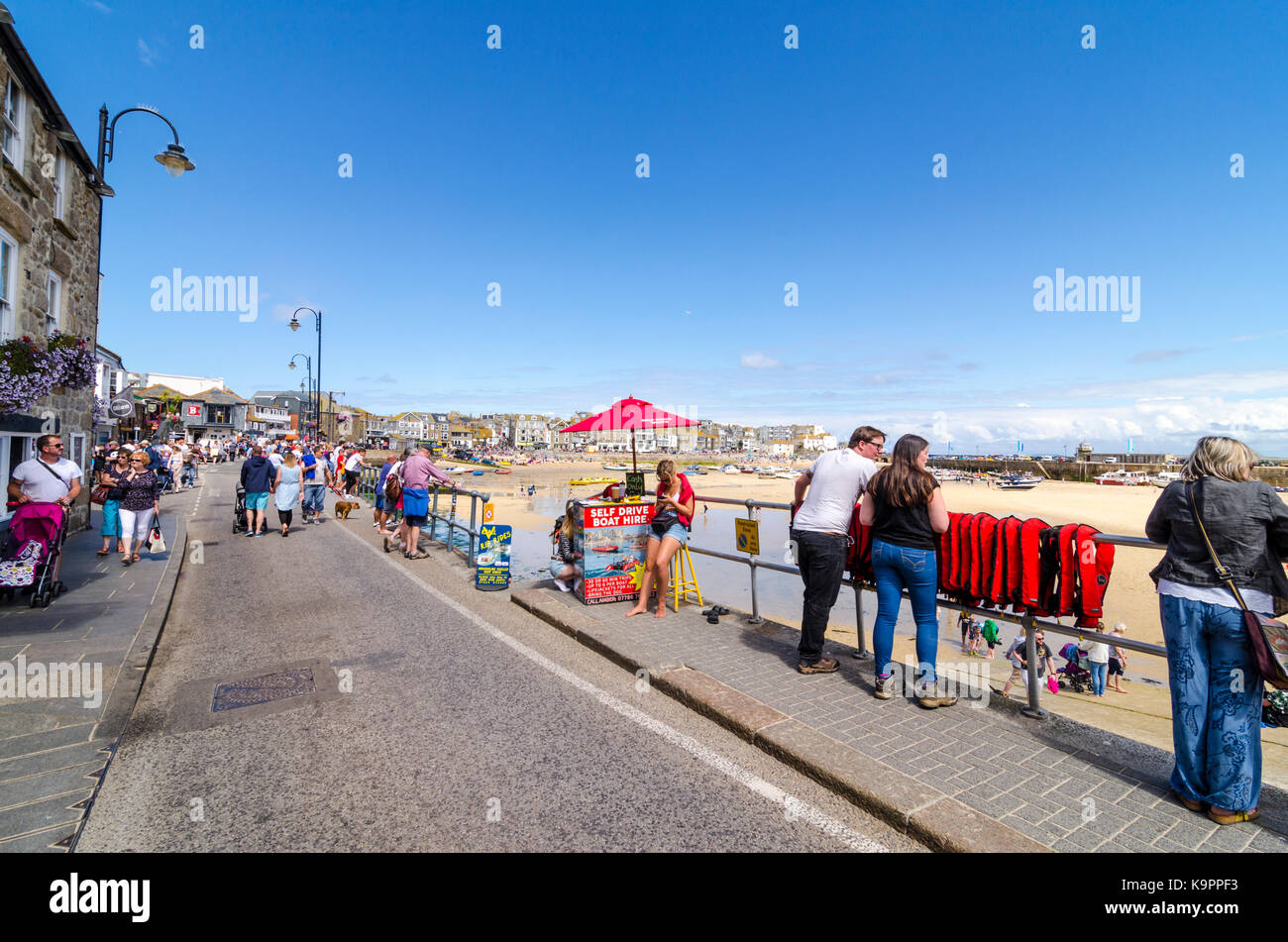 People on Wharf Road sea front. English coastal seaside town St Ives, Cornwall, England UK Stock Photo