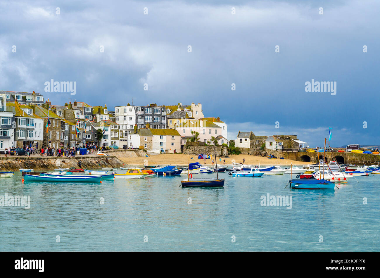 Boats moored and floating in St Ives harbour with rain clouds above. English coastal seaside town St Ives, Cornwall, England UK Stock Photo