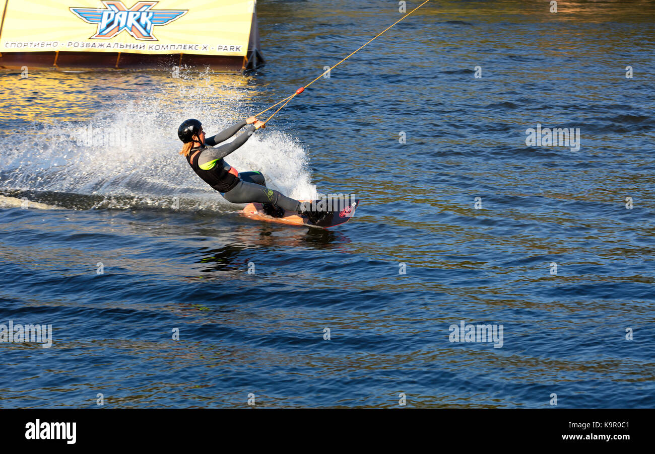 Woman practicing wakeboarding on the lake. This is an extreme sport. Stock Photo