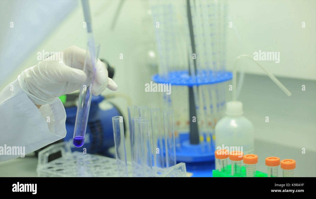 Test tubes closeup. Medical equipment. Close-up footage of a scientist using a micro pipette in a laboratory. Laboratory technician injecting liquid into a microtiter plate. Test tubes. Small depth of field. Stock Photo