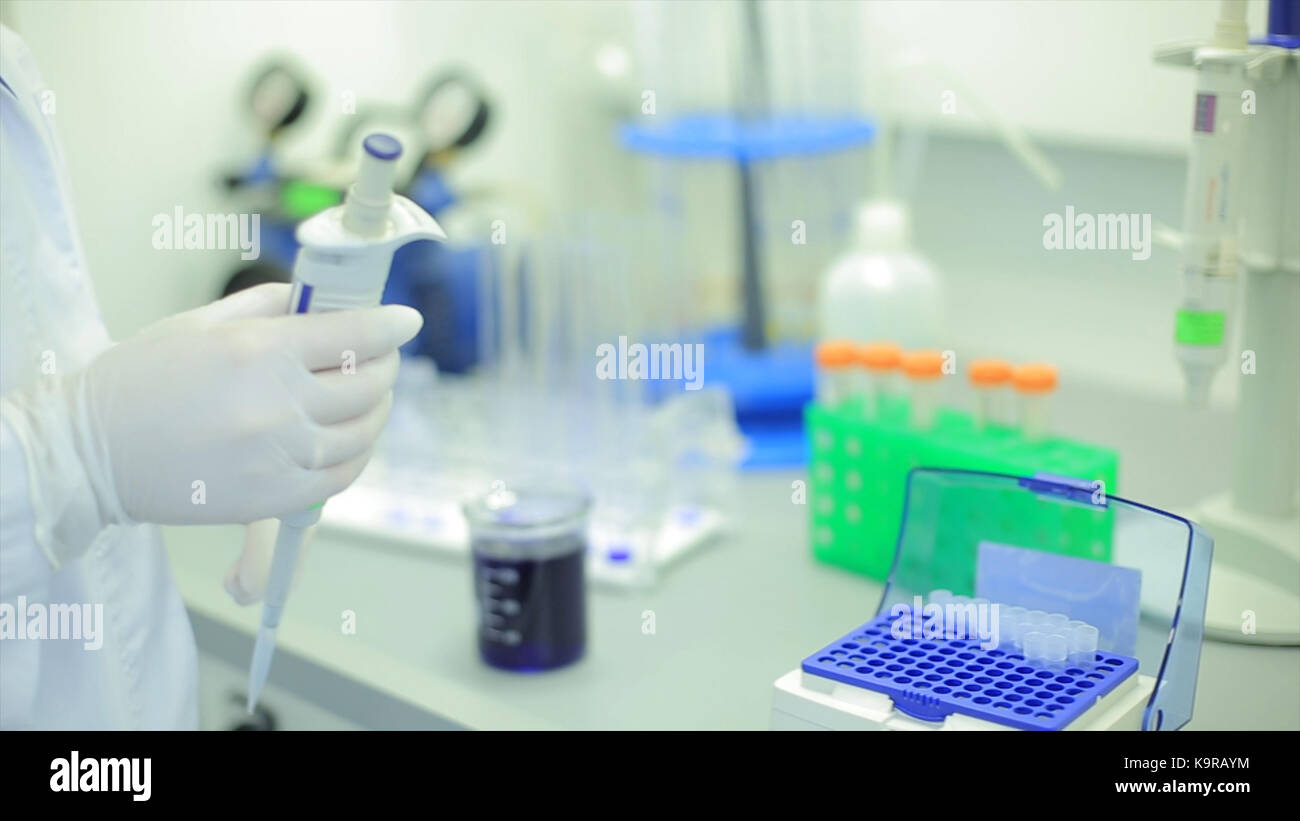 Test tubes closeup. Medical equipment. Close-up footage of a scientist using a micro pipette in a laboratory. Laboratory technician injecting liquid into a microtiter plate. Test tubes. Small depth of field. Stock Photo