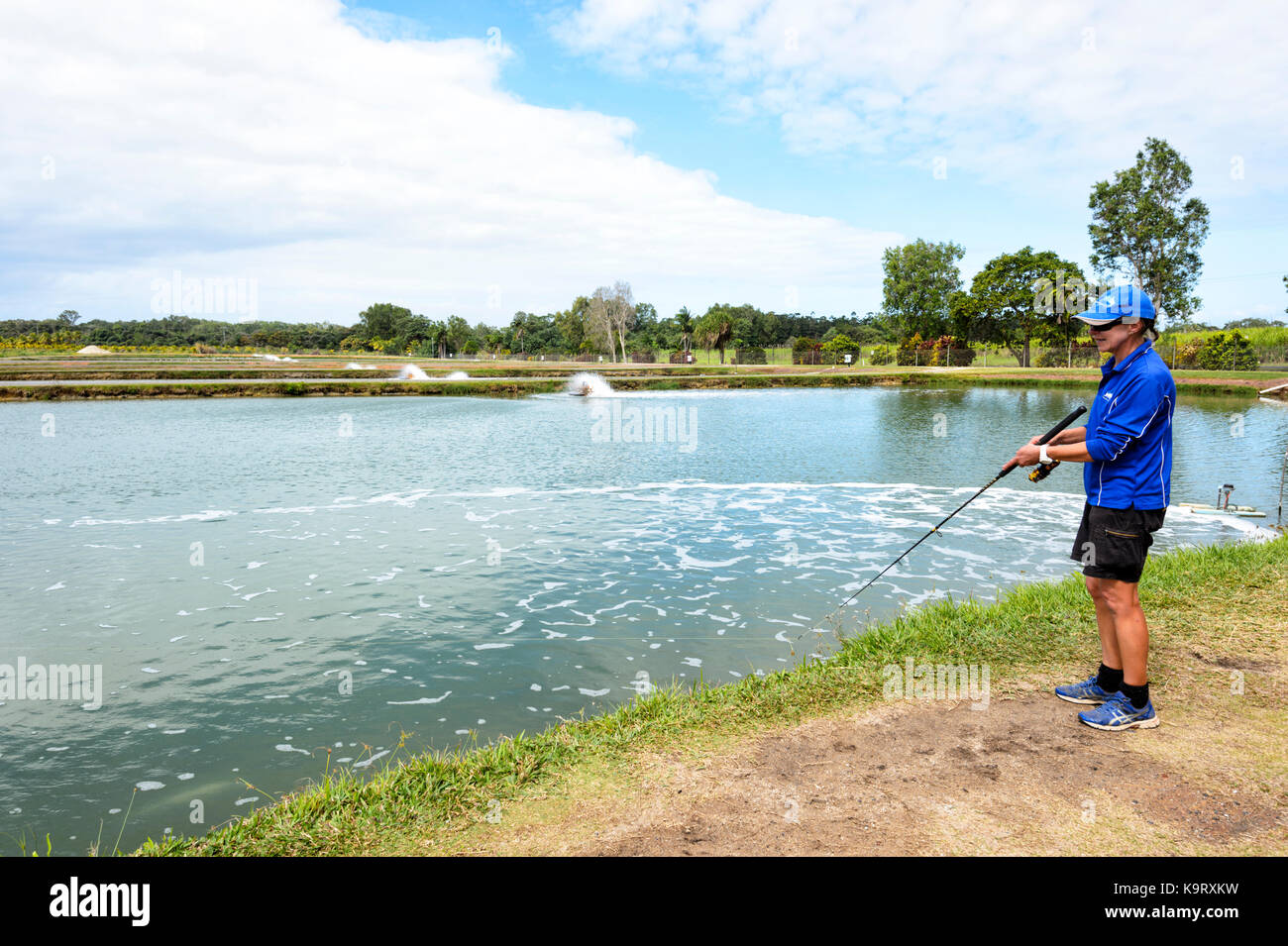 Woman fishing at a barramundi farm, Mossman, Far North Queensland, FNQ
