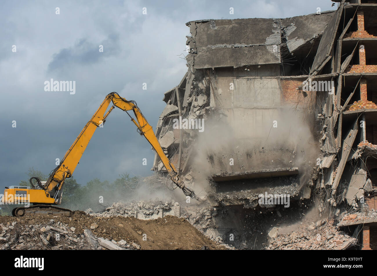 Heavy equipment being used to tear tearing down building construction. Moment of collapse. Stock Photo