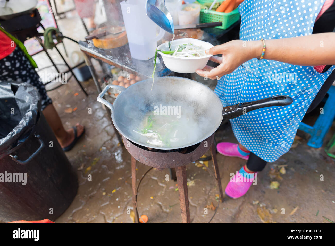 Woman Cooking Noodle Soup Outdoors On Traditional Street Market In Asia