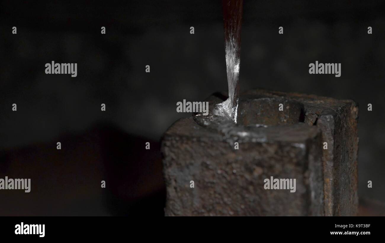 Pouring molten lead alloy into a mold. Manufactory, manual