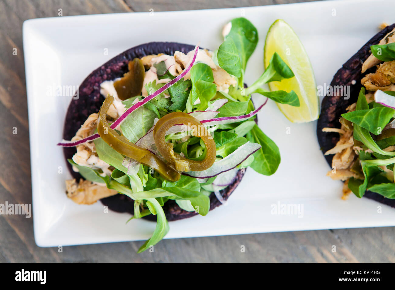 Blue tacos with chicken, lamb lettuce, red onions and jalapeno peppers Stock Photo