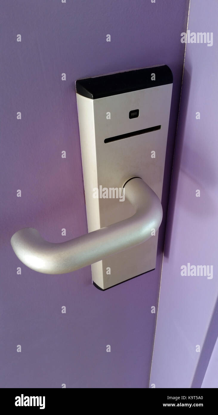 Magnetic Card Reader Door Lock on a purple door of a room in a hotel Stock Photo