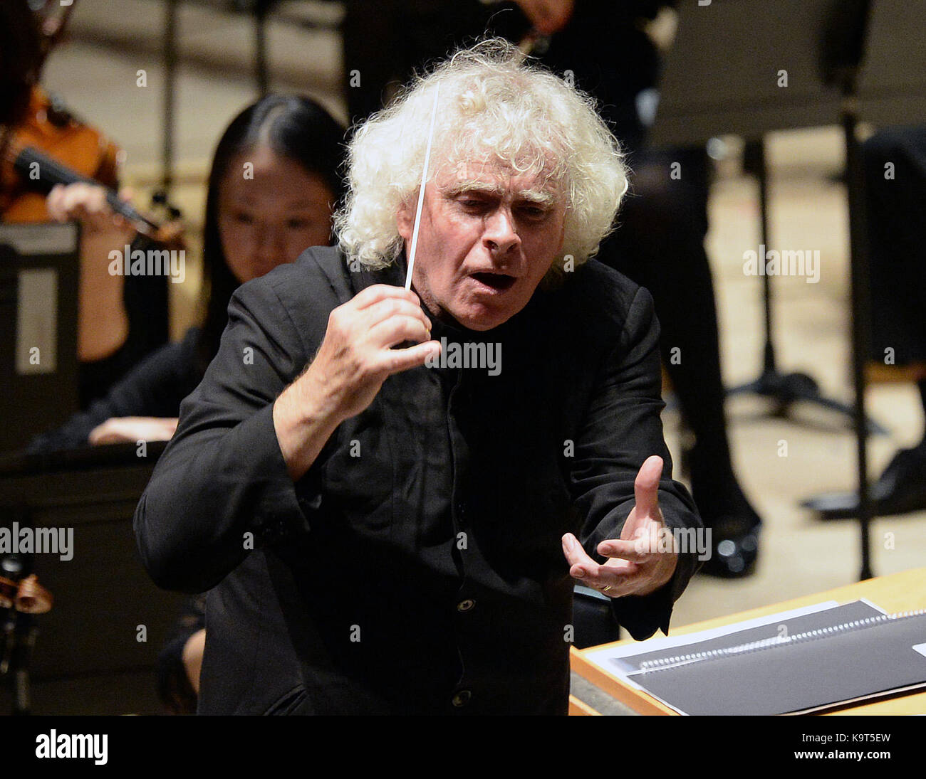 Sir Simon Rattle conducts 11-18-year-old musicians from east London on the closing day of ÔThis is Rattle', at the Barbican in London. PRESS ASSOCIATION. Picture date: Sunday September 24, 2017. The 54 young people perform with LSO players and musicians from the Guildhall School, all playing side-by-side on the Barbican stage, performing music from Elgar's ÔEnigma Variations' and Stravinsky's ÔThe Rite of Spring'. The performance is part of the ÔLSO On Track' programme, which has seen LSO players work with thousands of young people from east London since 2008, in activities Stock Photo