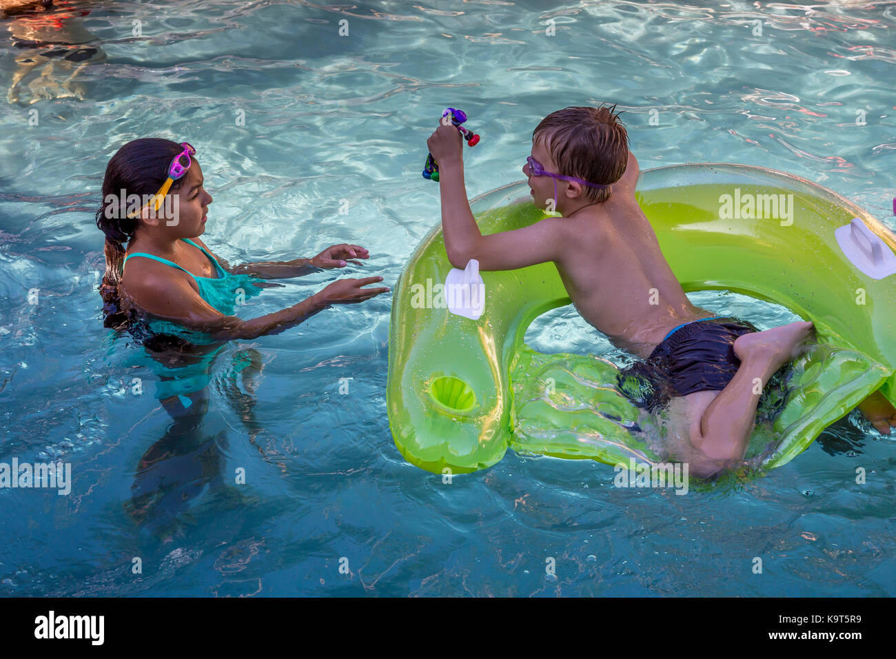 girl and boy, children, playing in pool, swimming pool, freshwater swimming pool, pool party, Castro Valley, Alameda County, California, United States Stock Photo