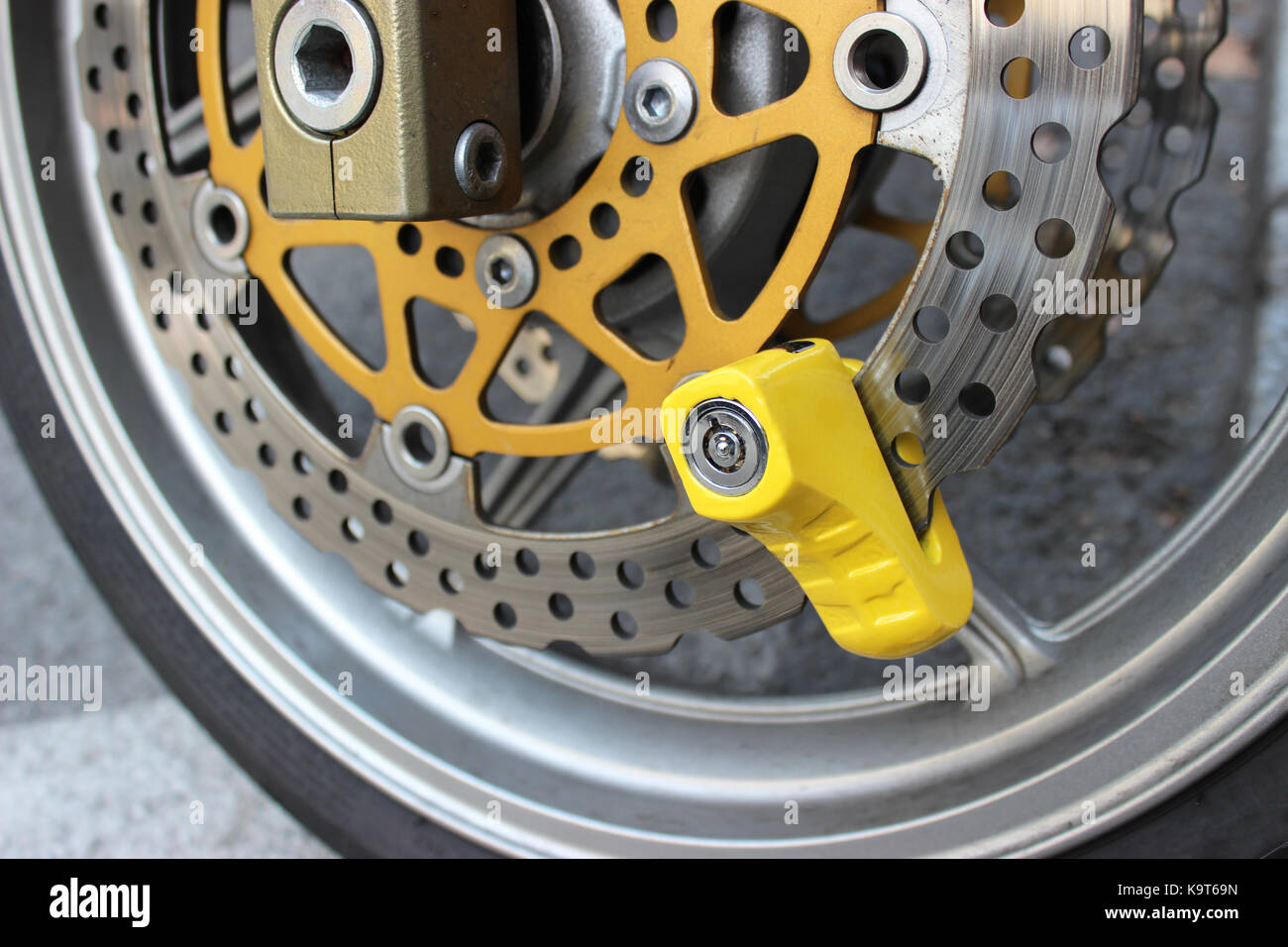 Yellow Disc Lock on Motorbike Disc Brake Stock Photo - Alamy