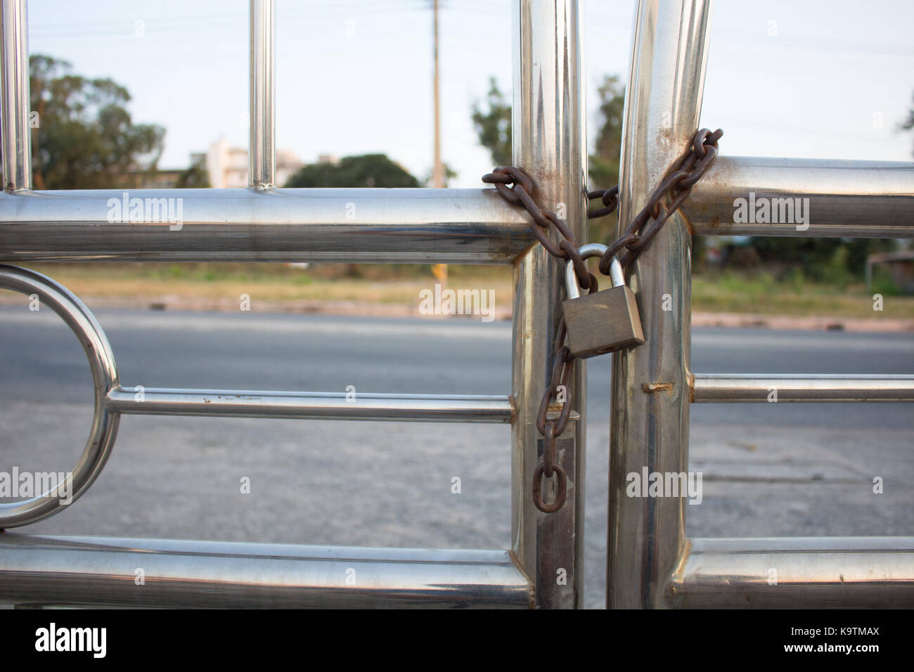 Gold Padlock with chain used on a chainlink fence. Selective focus is