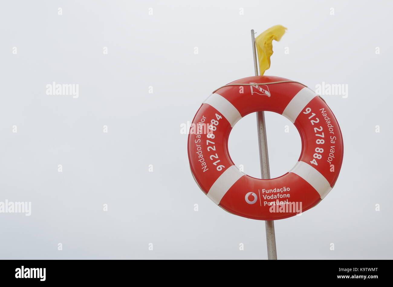 Beach yellow flag on a lifeguard pole in Lourinhã, Portugal Stock Photo