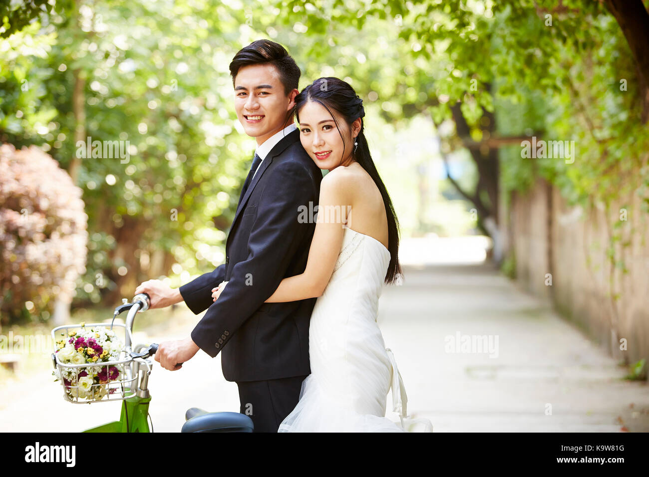 newly-wed asian bride and groom taking picture with a bicycle. Stock Photo