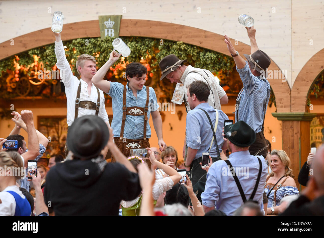 Munich, Germany. 24th Sep, 2017. Drunken visitors at the Oktoberfest entertain themselves with vast amounts of beer in Munich, Germany, 24 September 2017. Credit: Tobias Hase/dpa/Alamy Live News Stock Photo