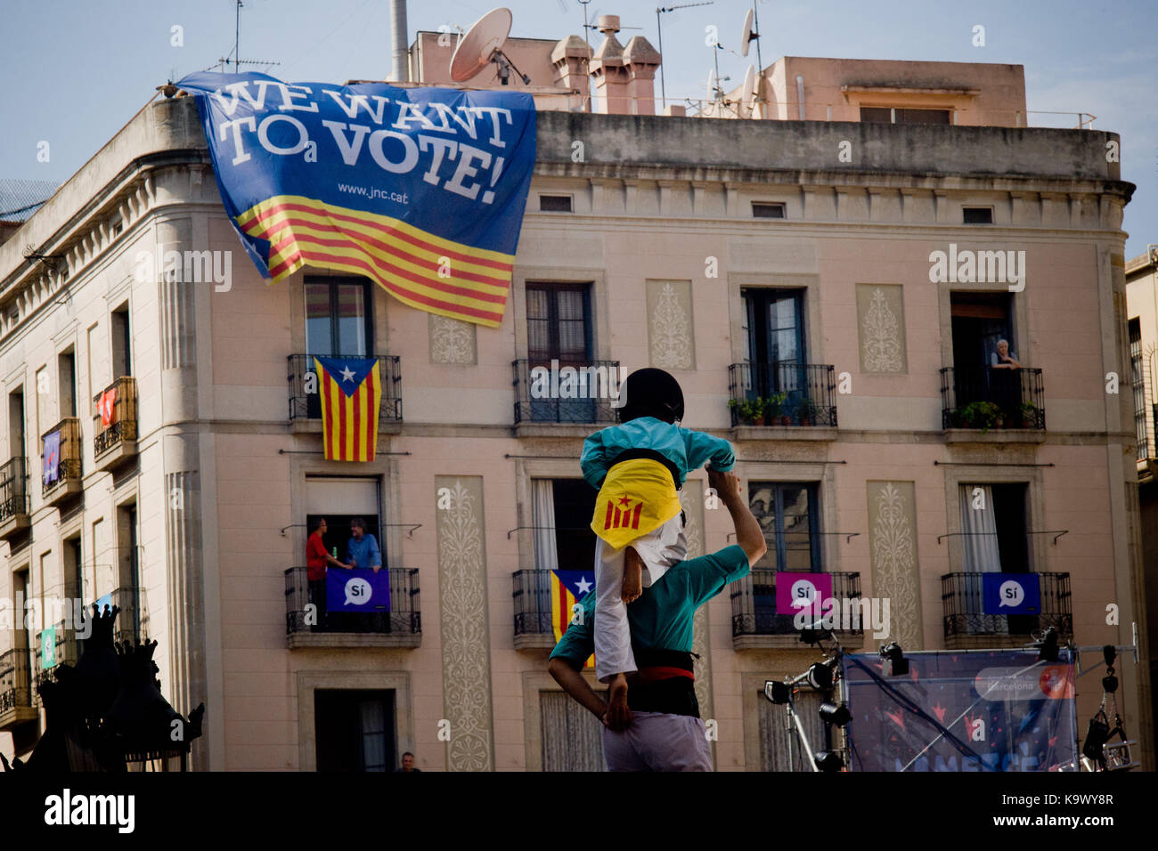 Barcelona, Catalonia, Spain. 24th Sep, 2017. Castellers building a human tower as a banners reading 'we want to vote' hangs from a building during La Merce festival in Barcelona. Catalan separatists and the Catalonia's government continue their campaign towards the referendum of October 1 despite the crackdown carried out by the Spanish government. Over 4,000 members of the Spanish National Police and Civil Guards are being transferred to Catalonia these days. Catalan government aims to celebrate a referendum on independence next first october, the Spanish government is frontally oppos Stock Photo