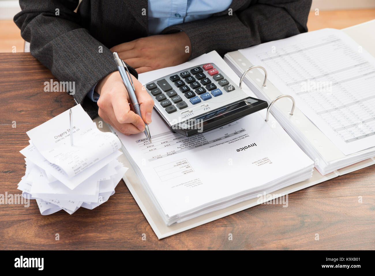 Close-up Of Businessperson Calculating Bills At Desk Stock Photo