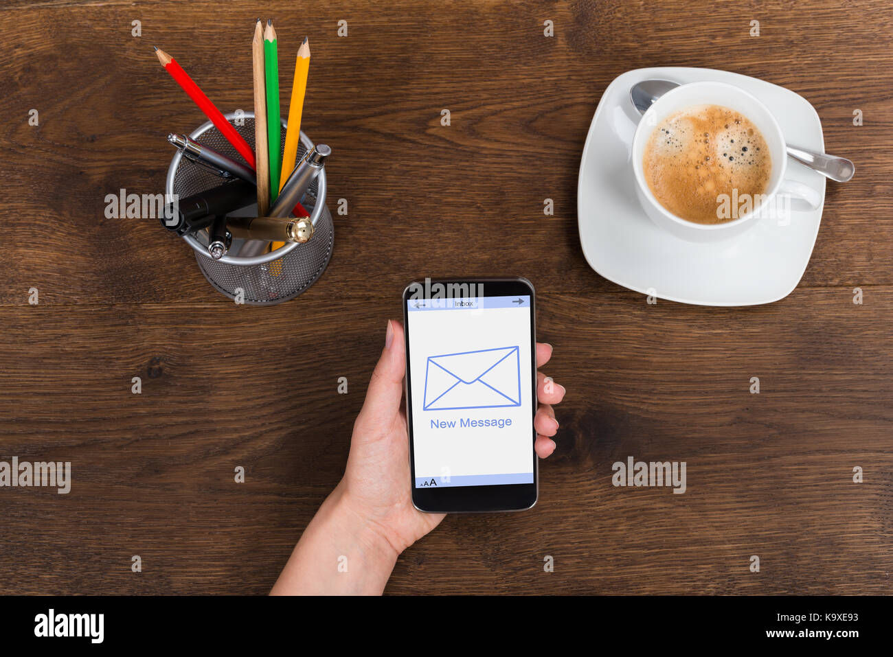 High Angle View Of Person Hand With Mobile Phone Showing New Message On Display Stock Photo