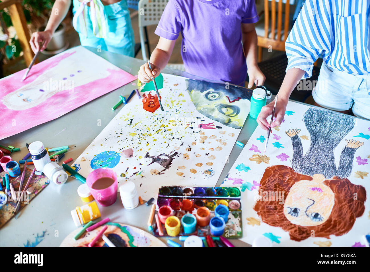 High angle of unrecognizable children painting pictures with ...
