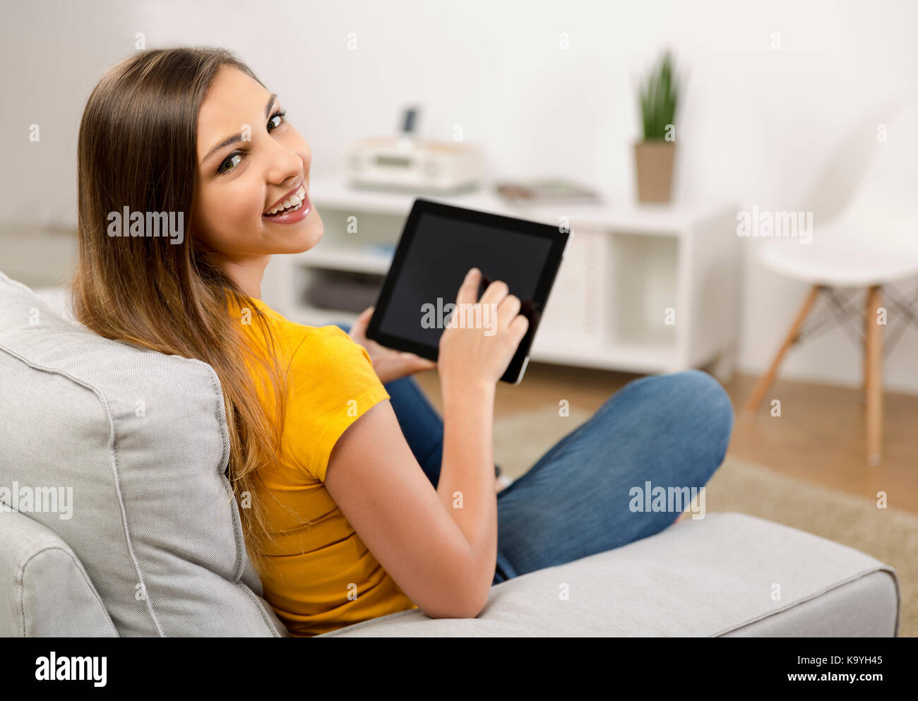 Beautiful woman at home working with a tablet Stock Photo - Alamy