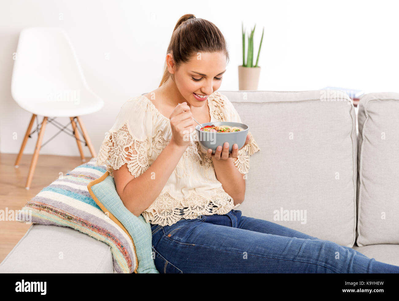 Beautiful woman at home eating a healthy bowl Stock Photo