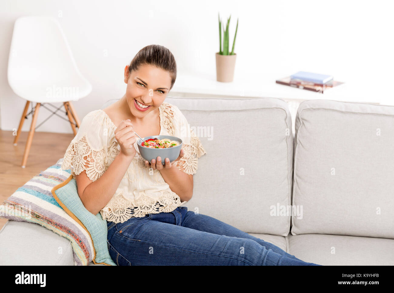 Beautiful woman at home eating a healthy bowl Stock Photo