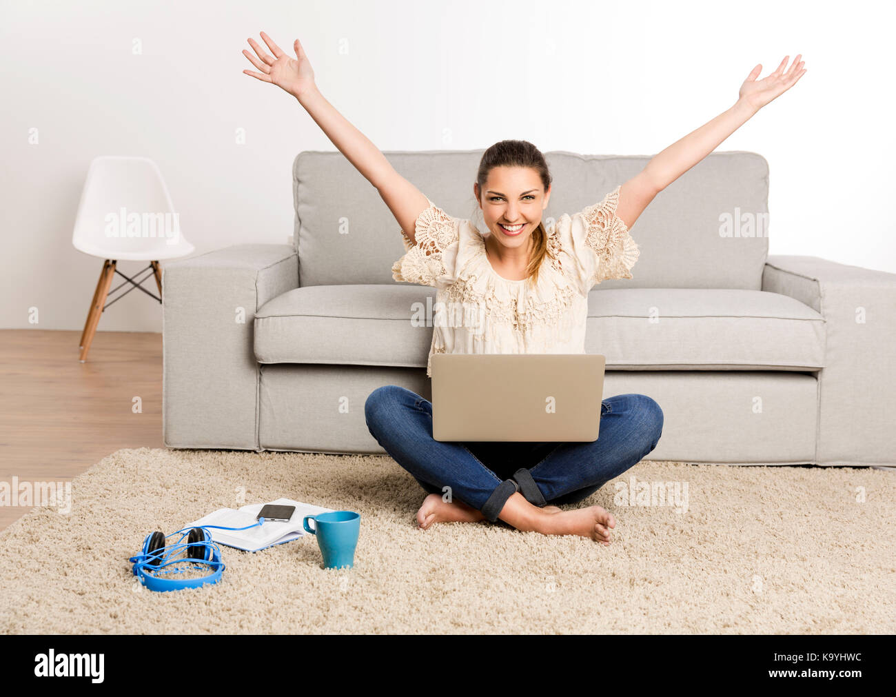 Beautiful happy woman at home working on her laptop Stock Photo