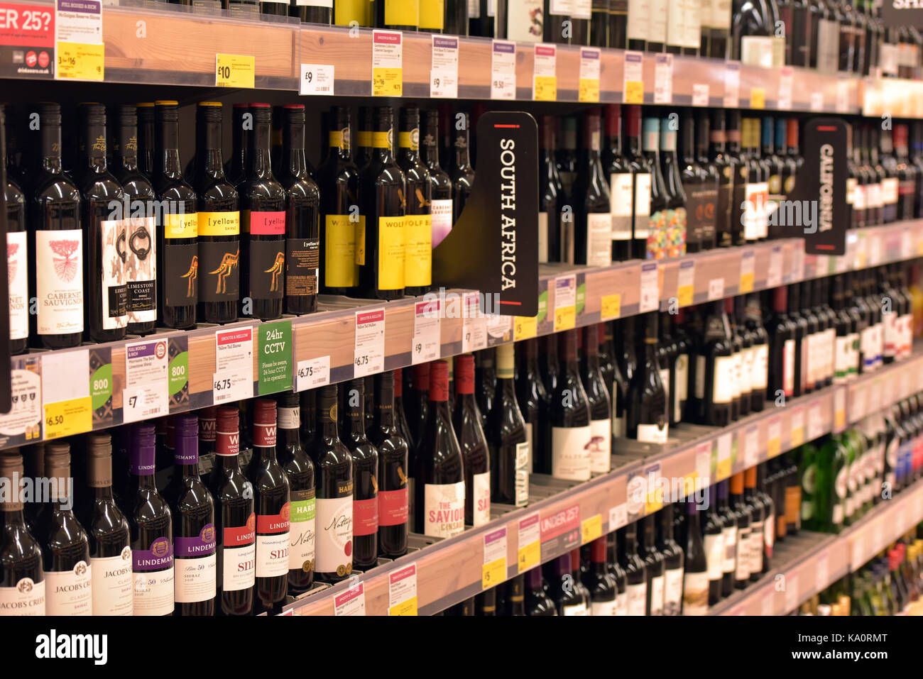 Bottles of wine for sale in a supermarket. Shelves full of red and white wine. Stock Photo